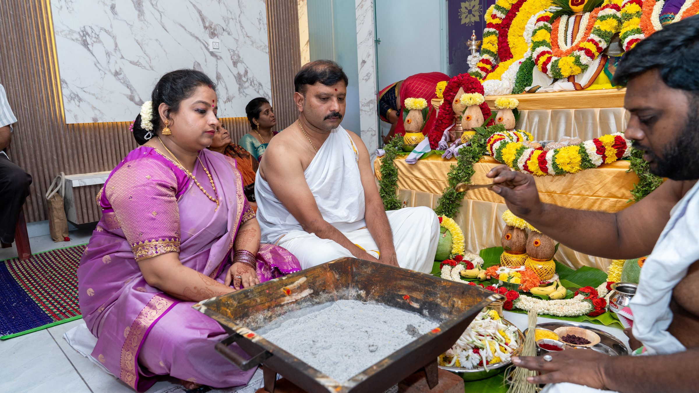 Couple performing the Griha Pravesha ritual seated at the decorated altar